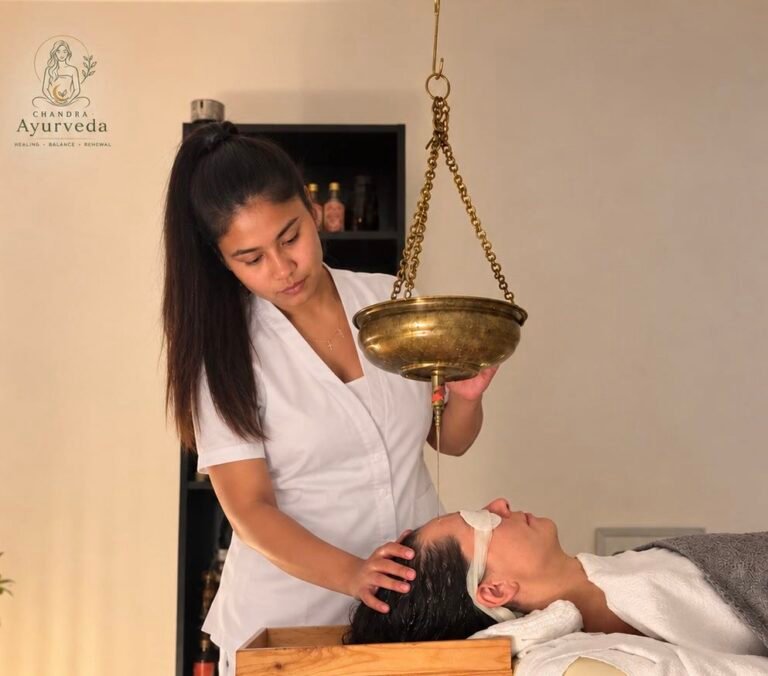 Shirodhara homlokolaj-kezelés: meleg gyógynövényes olaj csorog a vendég homlokára rézedényből — Chandra Ayurveda Budapest